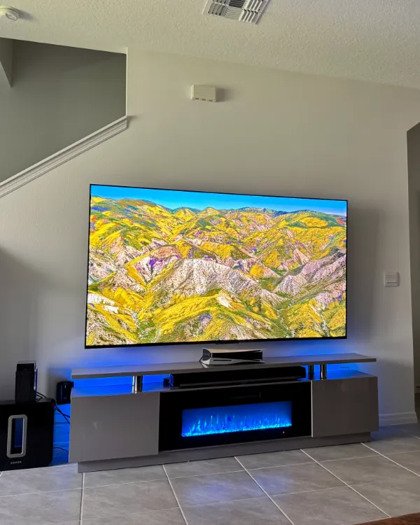 Large TV over a console with an electric fireplace in an open-plan living room